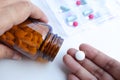 Woman holding medicine bottle pour pills into her hand.taking pills or antibiotics. Royalty Free Stock Photo