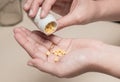 Woman holding medicines bottle and pouring some pills on another hand for treatment medication Royalty Free Stock Photo