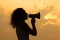 Woman holding megaphone at sunset