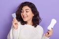 Woman holding menstrual cup and sanitary pad in hands. Feminine hygiene alternative product instead of tampon during her period.