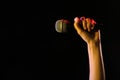 Woman holding microphone on black background, closeup Royalty Free Stock Photo