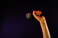 Woman holding microphone on black, closeup. Space for text Royalty Free Stock Photo