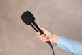 Woman holding microphone on color background Royalty Free Stock Photo