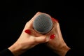 Woman hands with microphone isolated on black Royalty Free Stock Photo
