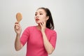 Woman holding a mirror, touch and worrying about her face Royalty Free Stock Photo