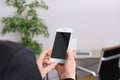 Woman holding mobile phone with blank screen in office, closeup. Royalty Free Stock Photo