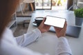 A woman holding mobile phone with blank white desktop screen in office Royalty Free Stock Photo