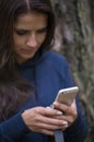 Woman holding mobile phone and headphones in hand against a blur Royalty Free Stock Photo