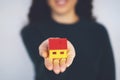 Woman holding model house in hands on white background Royalty Free Stock Photo