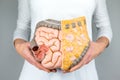 Woman holding model of human intestines in front of body