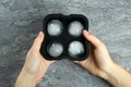 Woman holding mold with frozen ice balls at grey table, top view Royalty Free Stock Photo