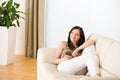 Woman holding music player listening in lounge