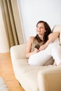 Woman holding music player listening on sofa home