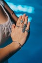 Woman holding namaste in clean water. Palms with gypsy boho rings. Meditation, praying, gratitude, purity background. Royalty Free Stock Photo