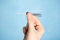 Woman holding needles for acupuncture on light blue background, closeup Royalty Free Stock Photo