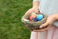 Woman holding nest with Easter eggs outdoors Royalty Free Stock Photo