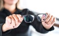 Woman holding new glasses. Lenses and spectacles getting fix and repair by professional optician. Royalty Free Stock Photo