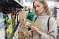 Woman holding oil bottles at supermarket. Buyer& x27;s hand choosing bio food olive oil in grocery store. Royalty Free Stock Photo