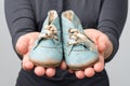 Woman holding old retro baby shoes in hands.