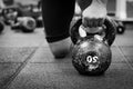 Woman holding old and rusty kettle bell on to the gym floor.