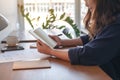 A woman holding and opening a blank notebook with coffee cup and papers on the table Royalty Free Stock Photo