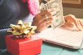 Woman holding paper currency and credit card while using laptop, Online shopping on Christmas seasonal Royalty Free Stock Photo