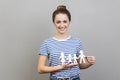 Woman holding paper family chain, looking at camera with toothy smile. Royalty Free Stock Photo