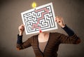 Woman holding a paper with a labyrinth on it in front of her head