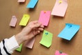 Woman holding paper note pinned to cork board, closeup Royalty Free Stock Photo