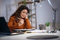 Young woman holding papers in her hands, calculating family budget at home Royalty Free Stock Photo