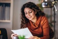 Woman holding papers in her hands, calculating family budget Royalty Free Stock Photo