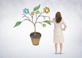 Woman holding pen and Drawing of Business graphics on plant branches on wall Royalty Free Stock Photo