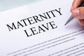 Woman`s Hand Filling Maternity Leave Form Over Desk Royalty Free Stock Photo