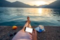 Woman holding phone lying on the pier Royalty Free Stock Photo