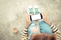 Woman holding phone white screen on top view vintage style