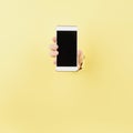 Woman holding phone in wrapped hole in pink background, copy space