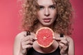 Woman holding piece of grapefruit isolated on pink Royalty Free Stock Photo