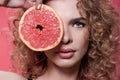 Woman holding piece of grapefruit isolated on pink Royalty Free Stock Photo