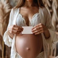 a woman is holding a piece of paper, pregnant belly