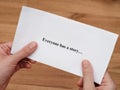 A woman holding a piece of paper with the words Everyone has a story written on it Royalty Free Stock Photo