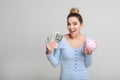 Woman holding piggy bank and dollar bills Royalty Free Stock Photo