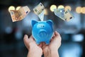 Woman holding piggy bank and Euro banknotes falling, closeup Royalty Free Stock Photo