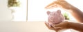 A woman holding a piggy bank in the shape of a pink pig. Royalty Free Stock Photo