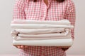 Woman holding a pile of clean ironed linen