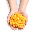 Woman holding pile of crunchy cheesy corn sticks on white background, top view Royalty Free Stock Photo