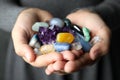 Woman holding pile of different gemstones