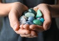 Woman holding pile of different gemstones