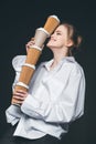 Woman holding pile of disposable coffee cups
