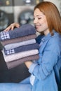 woman holding pile ironed clean towels