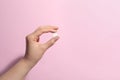 Woman holding pill on pink background, closeup. Space for text Royalty Free Stock Photo